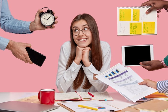 brunette-woman-sitting-desk-surrounded-with-gadgets-papers