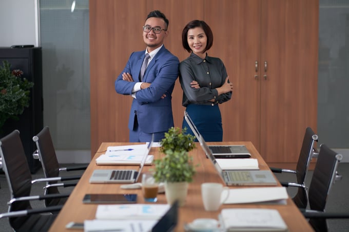 male-female-asian-executives-posing-top-meeting-table-boardroom