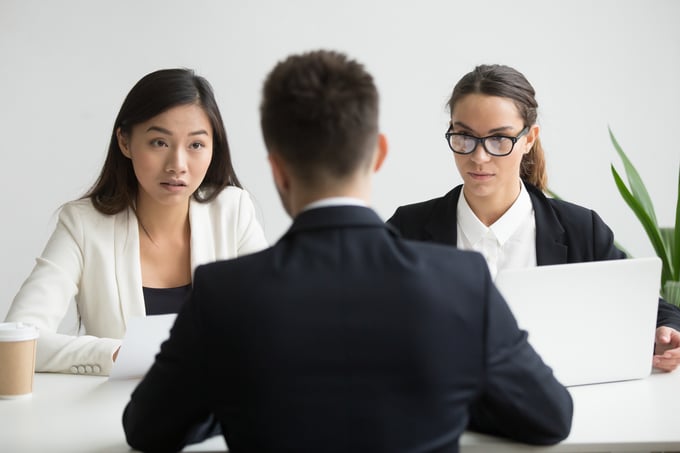 serious-unconvinced-diverse-hr-managers-interviewing-male-job-applicant
